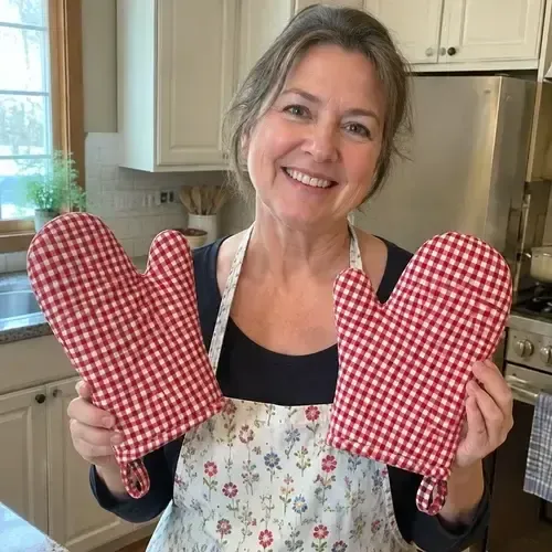 Persona mostrando guantes de cocina a cuadros rojos